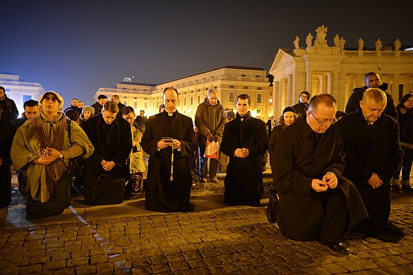 Gläubige knien und beten am Abend des 28.02.2013 auf dem Petersplatz in Rom zum Ende der Amtszeit von Papst Benedikt XVI.