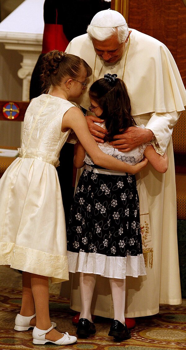Zwei Mädchen umarmen Papst Benedikt XVI. herzlich