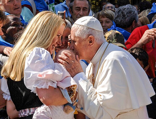 apst Benedikt XVI. begrüßt eine Frau mit einem Baby, Josefa Schmid, während seines Besuchs am 11. September 2006 in Altötting. Er küsst das Baby auf den Kopf.