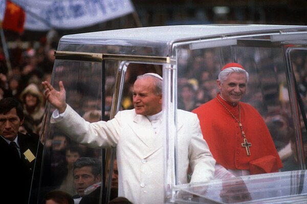 Papst Johannes Paul II. (l.) und Kardinal Joseph Ratzinger, Erzbischof von München und Freising, begrüßen am 19. November 1980 bei einer Fahrt durch München die Gläubigen aus dem Papamobil. Papst Johannes Paul II. besuchte vom 15. bis 19. November 1980 Deutschland.