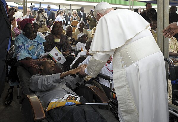 Wohin auch immer Benedikt XVI. reiste, Kranken und Behinderten gehörte seine besondere Aufmerksamkeit. Er hält die Hand eines Kranken.